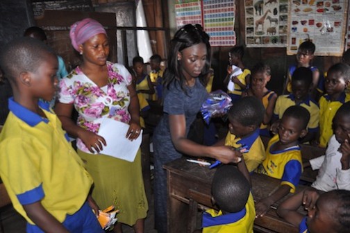 Oluwaseun Olufemi  distributing exercise books, crayons, pencils and other educational materials to students of Whanyinna Nursery and Primary School Makoko Water Front, Yaba Lagos