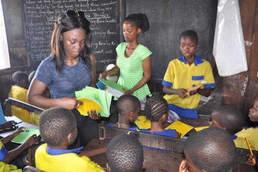 Oluwaseun Olufemi  distributing exercise books, crayons, pencils and other educational materials to students of Whanyinna Nursery and Primary School Makoko Water Front, Yaba Lagos