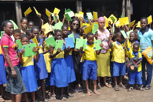 The executive director, The Vital Initiative Africa, Oluwaseun Olufemi, (middle) flanked by pupils and teachers of Whanyinna Nursery and Primary School Makoko Water Front, Yaba during the distribution of exercise books, crayons, pencils and other educational materials to the school Photo: Muyiwa Hassan
