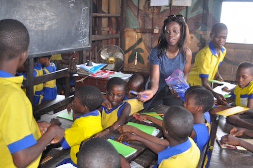 Oluwaseun Olufemi  distributing exercise books, crayons, pencils and other educational materials to students of Whanyinna Nursery and Primary School Makoko Water Front, Yaba Lagos Photo: Muyiwa Hassan