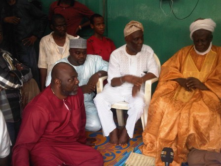 From right, Seriki Alhaji Adamu Umar, Prince Soji Ladejobi, Captain Nurudeen Olokowo in red attire sitting on the floor at the palace and others. 