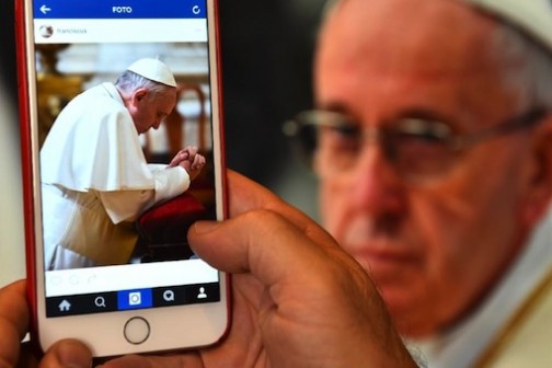 A man looks at the Instagram account of Pope Francis (Franciscus) on March 19, 2016 in Rome (AFP Photo/Gabriel Bouys)