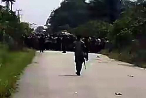 A soldier patrolling the border of both communities as villagers look on