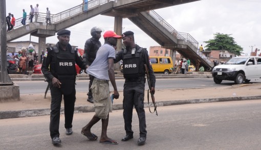 A Pedestrian being apprehended for crossing the expressway at Ketu, Ikorodu Road, Lagos by men of the Rapid Response Squad (RRS), on Monday, April 11, 2016.