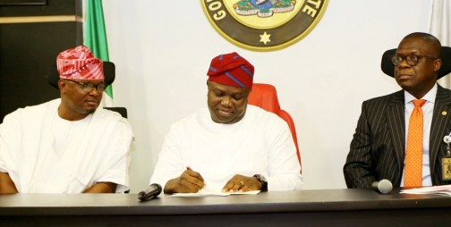 Lagos State Governor, Mr. Akinwunmi Ambode (middle), signing into Law the Lagos State Independent Electoral Commission (LASIEC), Local Government Tribunal and Administration Amendment Laws, while the Majority Leader, Lagos House of Assembly, Hon. Sanai Agunbiade (left) and Attorney General & Commissioner for Justice, Mr. Adeniji Kazeem (right) watch, during the signing of the Amended Laws at the Conference Room, Lagos House, Ikeja, on Thursday, May 5, 2016