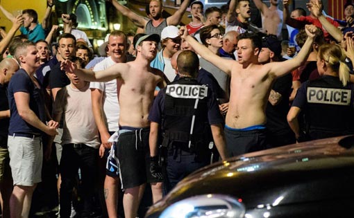 Police stand guard as England fans gather and chant slogans in the port area of Marseille, late on June 9, 2016, ahead of the start of the Euro 2016 football tournament in France. AFP PHOTO / LEON NEAL