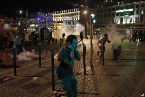 People run after police fired tear gas following clashes after the Euro 2016 soccer championship group B match between England and Russia in Marseille, France on June 11, 2016. Photo: VOA