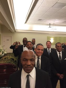 Mike Tyson front and center is seen above smiling with some o_the pall bearers at Ali's funeral. Daily Mail of London Picture