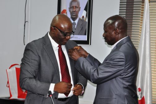 EFCC acting Chairman, Ibrahim Magu (right) decorating Mr Onanuga with the anti-corruption badge during the visit