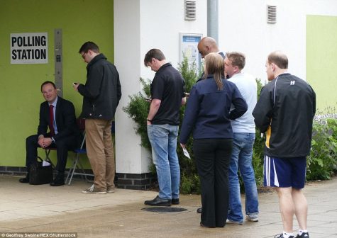 Voters queue to enter a polling station in Readin, London