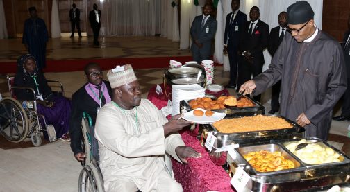 President Muhammadu Buhari serving food to one of his guests