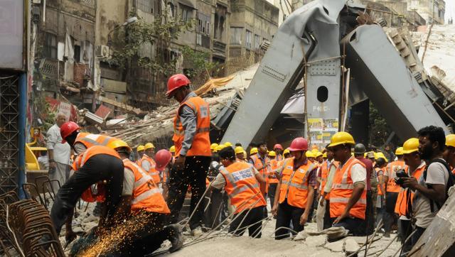 Emergency rescue workers at the site of the bridge that collapsed in India