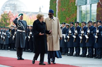 German Chancellor Angela Merkel, left, and the President of Nigeria Muhammadu Buhari, right, review the honor guards prior to talks at the chancellery in Berlin, Friday, Oct. 14, 2016.