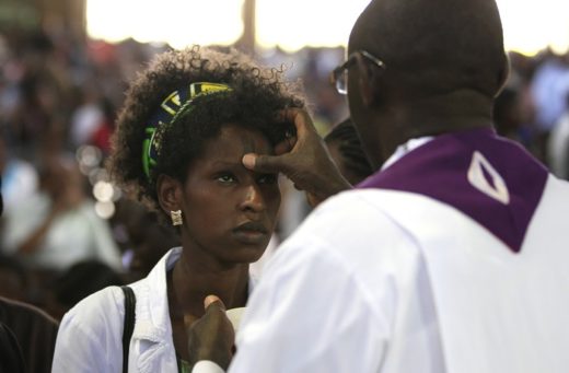 A Roman Catholic priest use ash to mark a cross on the forehead of a faithful during the Ash Wednesday mass at the holy Family minor basilica parish in Kenya’s capital Nairobi