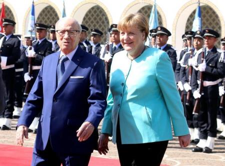 Tunisia’s President Beji Caid Essebsi and German Chancellor Angela Merkel walk past a guard of honour at Carthage Palace in Tunis