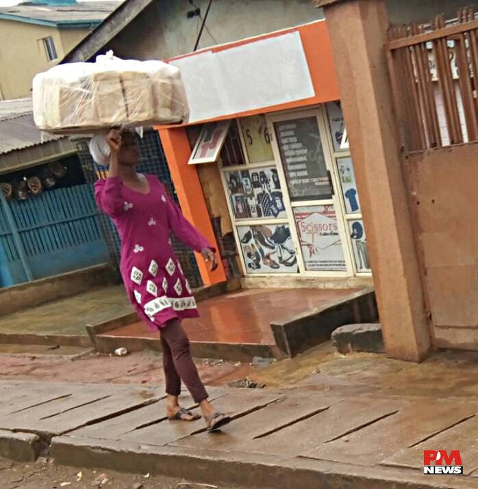 Bread Seller braves rain to hawk @ Ile-Epo.