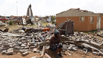 Flooded homes in Eastern Cape after severe 2025 storms, rescue teams searching rivers near Mthatha, damaged school bus swept away by floodwaters, children clinging to trees during floods, community volunteers distributing aid, damaged rural roads and bridges, power outages affecting Eastern Cape residents, local leaders Oscar Mabuyane and Cyril Ramaphosa coordinating relief, heavy rain and winter storm impact, climate change increasing flood risks, solidarity among Eastern Cape communities, Joburg ETC