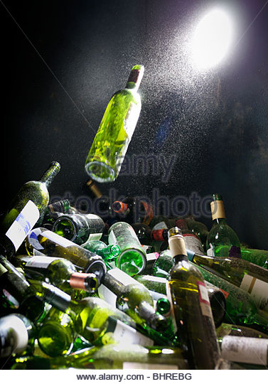 a-glass-bottle-being-pushed-into-a-glass-recycling-bin-bhrebg