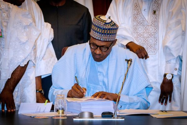 President-Buhari-signing-the-mutilated-budget-e1529527618269