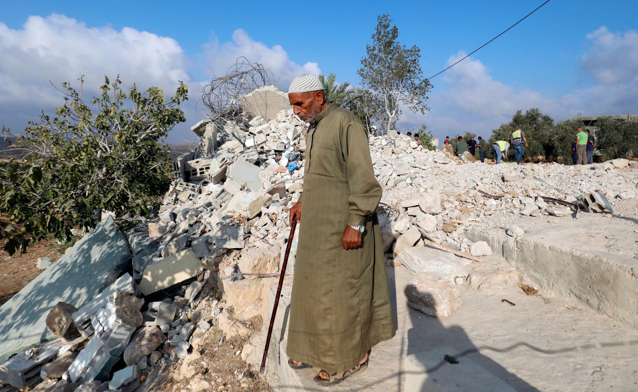 Man walks past the rubble of the family house of Palestinian assailant Mohammed Youssef after it was demolished by Israeli troops in the village of Kobar near Ramallah, in the occupied West Bank