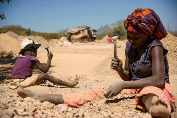 A-child-and-a-woman-break-rocks-extracted-from-a-mine-at-a-copper-quarry-and-pit-in-DR-Congo-1