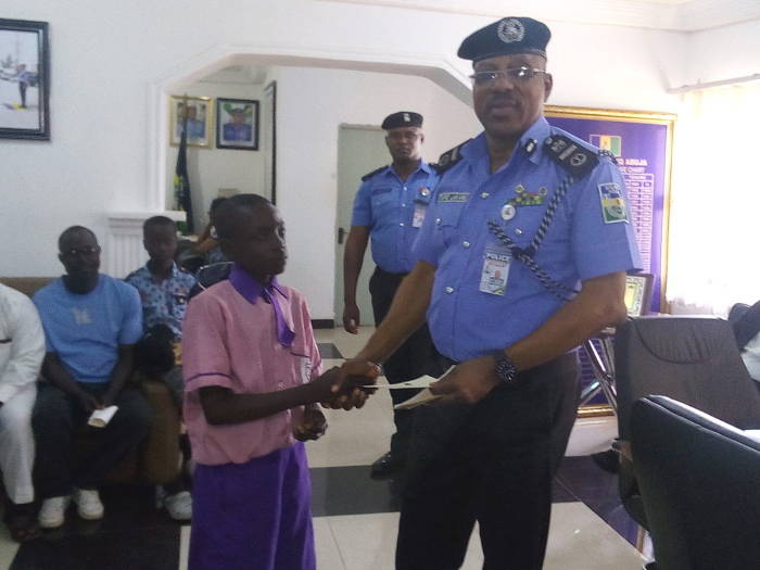 AIG In Charge Of Zone 7, Abuja, Taiwo Lakanu, presenting a cheque to a beneficiary of a deceased Police Officer in Abuja