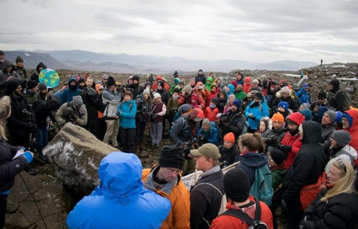 People gather at the site of the Okjokull glacier which has been melted by climate change