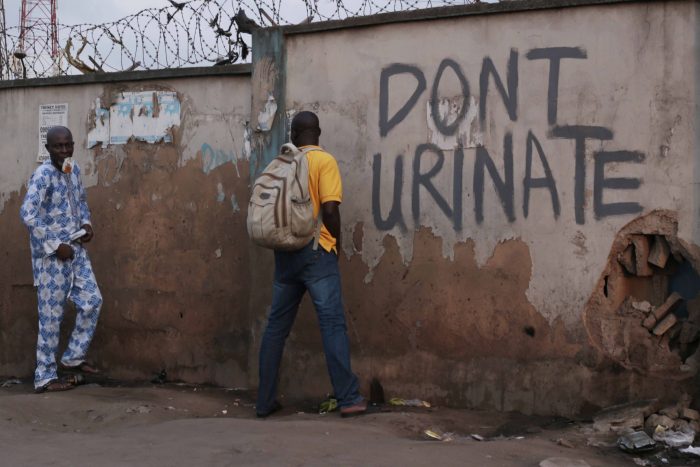 Unrepantant rule breaker indisciminately urinating outdoor despite the sign in Ketu, Lagos