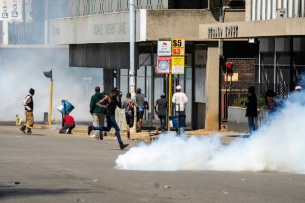 Zimbabwe Riot Police throw teargas at some people