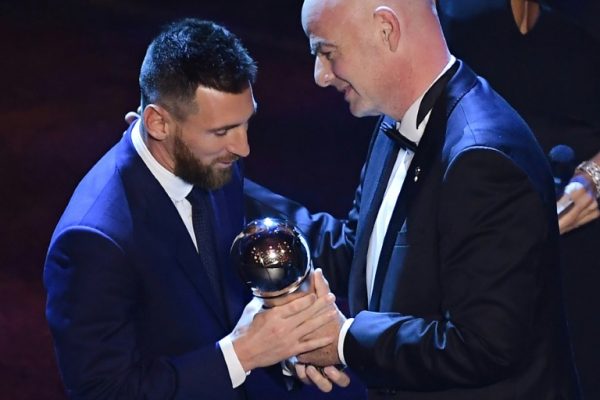 Lionel Messi takes his trophy from FIFA chief Gianni Infantino