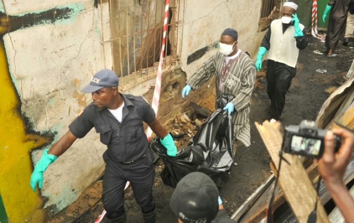 Rescue officers take out the remains of kids killed in the Koranic school fire near Monrovia