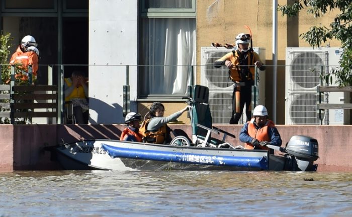 Rescuers move people by boat as homes were flooded