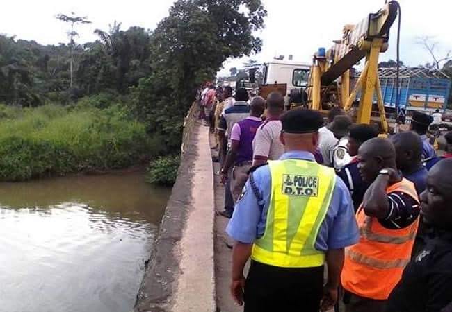people gather near the river the passenger bus disappeared into