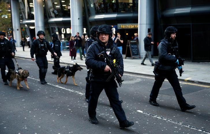Police officers with sniffer dogs walk in the City, near the site of an incident at London Bridge in London