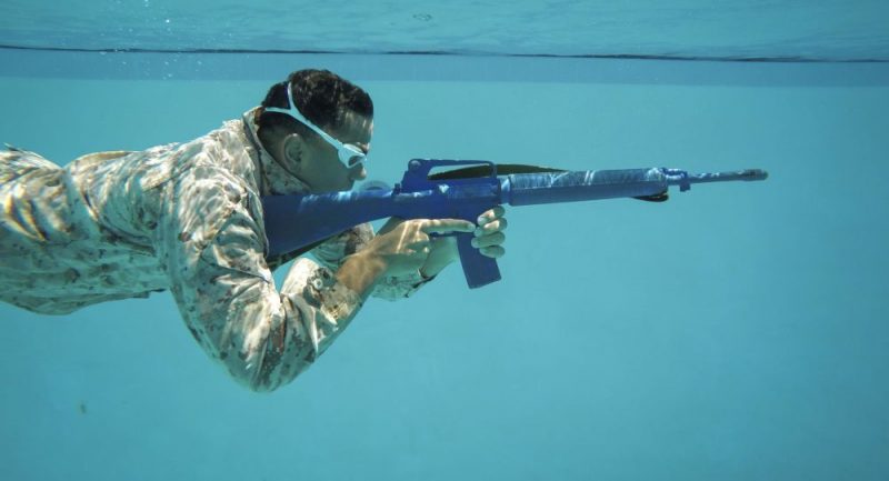 A soldier fires under water