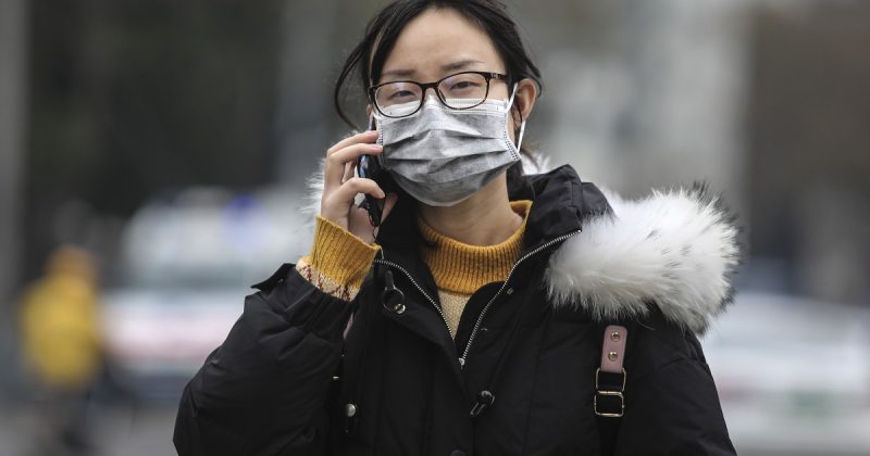 A person wears a mask for protection against the contagious SARS-like virus
