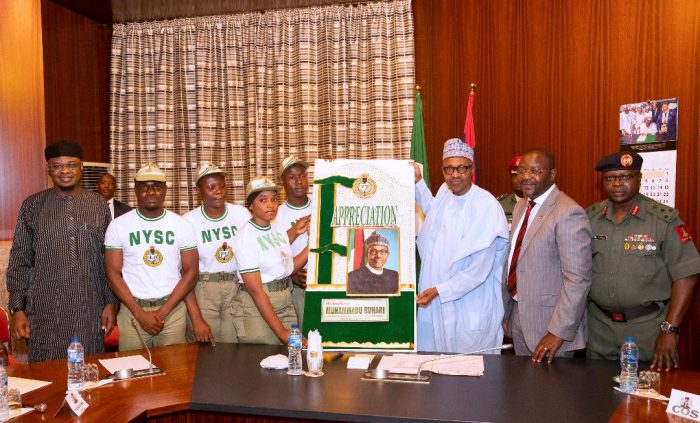 The corps members present appreciation card to President Buhari