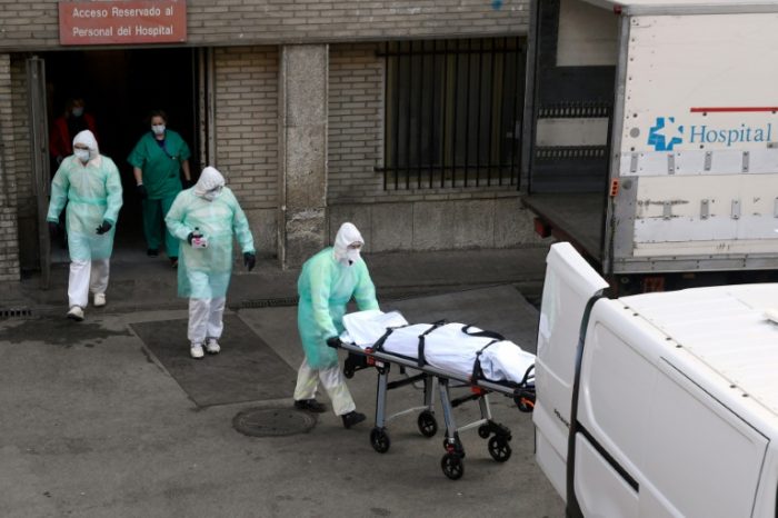 A health worker stretchers a dead body in Madrid