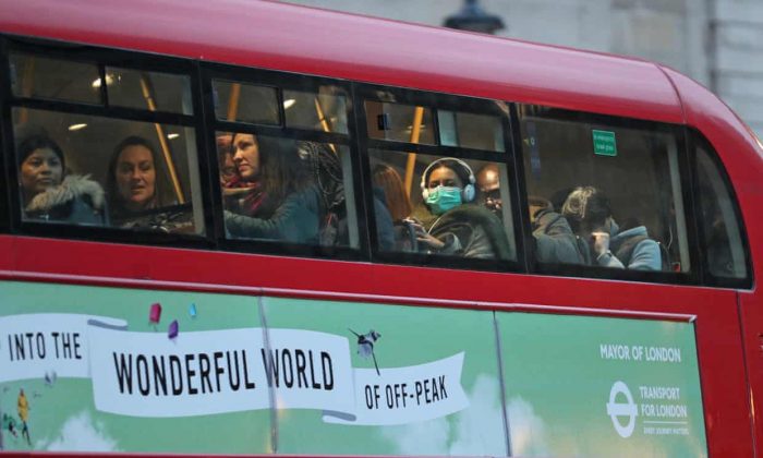 A woman wears coronavirus face mask inside a bus in London