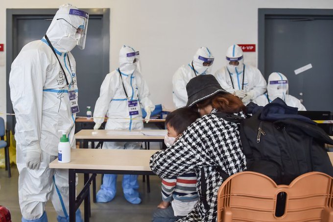 A. woman and her child go through screening at Beijing Airport. 145 imported coronavirus cases in Beijing by Wednesday