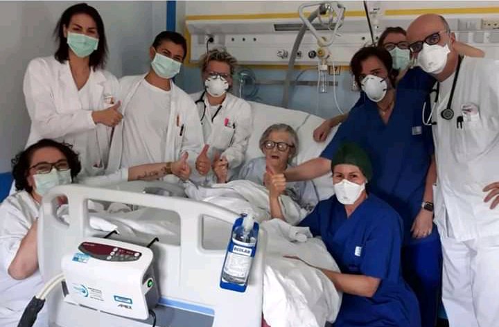 Doctors and nurses with an 85 year-old woman who survived coronavirus in Italy