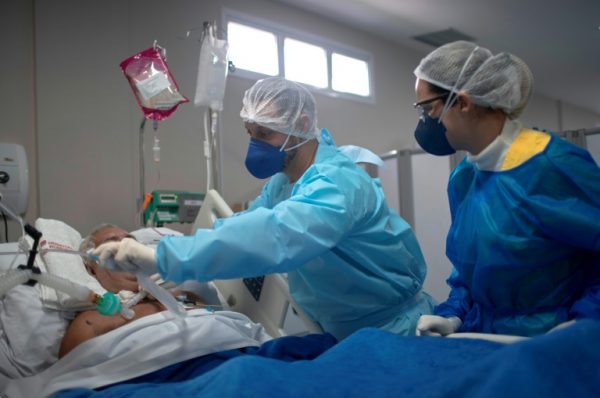 A Brazilian nurse in Rio de Janeiro checks a COVID-19 patient