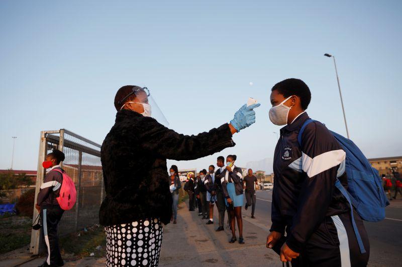 A teacher checks the temperature of a pupil in Cape Town South Africa on Monday. Reuters Photo
