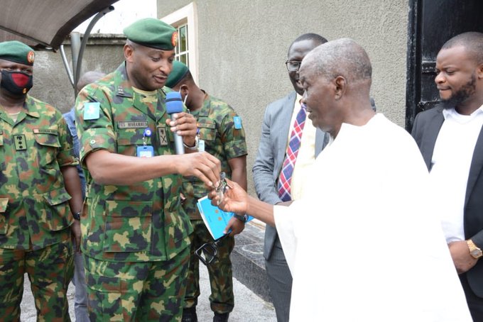 Retired warrant officer Paul Ojo, being handed the keys to his new house by an emissary of Lt. General Buratai