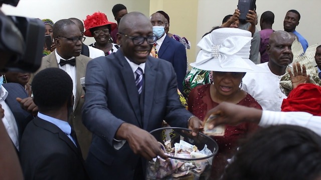 Ize-Iyamu collecting Thanksgiving offering in the church