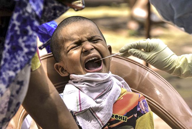 Un-professionnel-de-santé-collecte-un-échantillon-à-un-enfant-pour-le-dépistage-du-COVID-19-dans-le-bidonville-de-Dharavi-à-Bombay-en-Inde-le-6-juin-2020.-Str-Xinhua-650×439