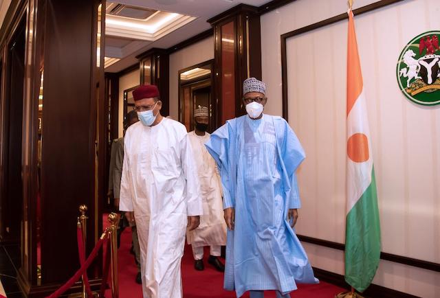 Buhari, right, leads his Nigerien guest Bazoum to dinner