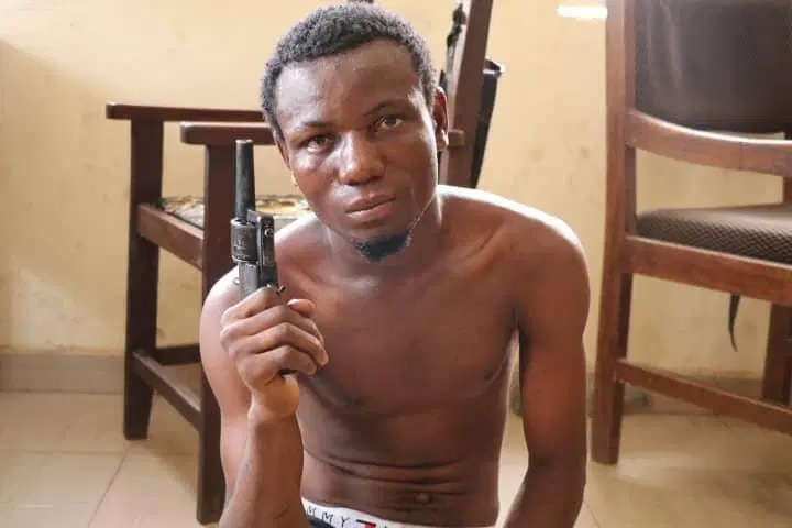 Kogi Polytechnic student,  Shehu Mohammed holding the locally made gun found in his possesion