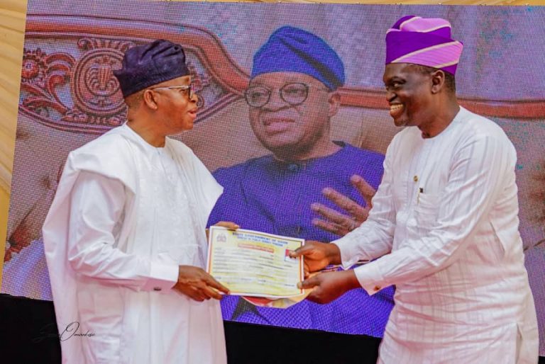 Oyetola presents a bond certificate to one of the retirees