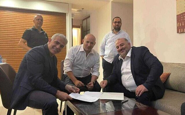 Yesh Atid leader Yair Lapid (L), Yamina leader Naftali Bennett (C) and Ra’am leader Mansour Abbas sign a coalition agreement on June 2, 2021